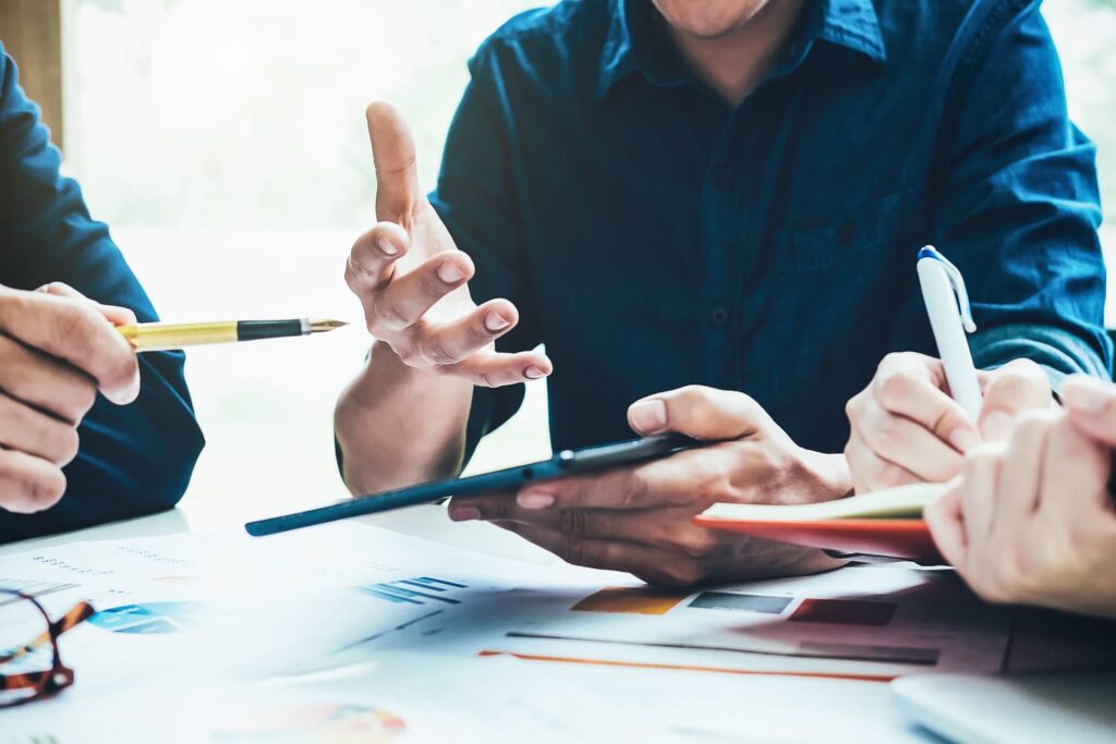 Three people at a table presenting a strategic business valuation with Commonwealth M&A